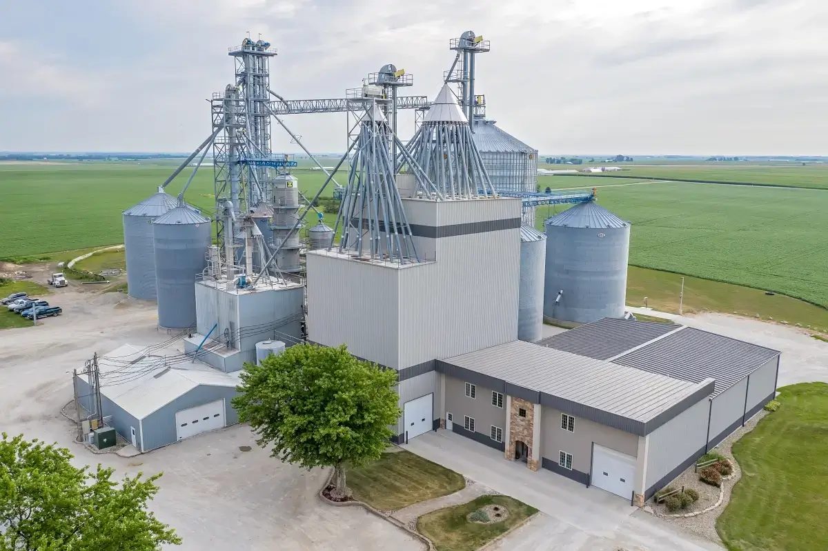 Aerial drone photo of a grain elevator complex with silos surrounded by farm fields, Central Illinois