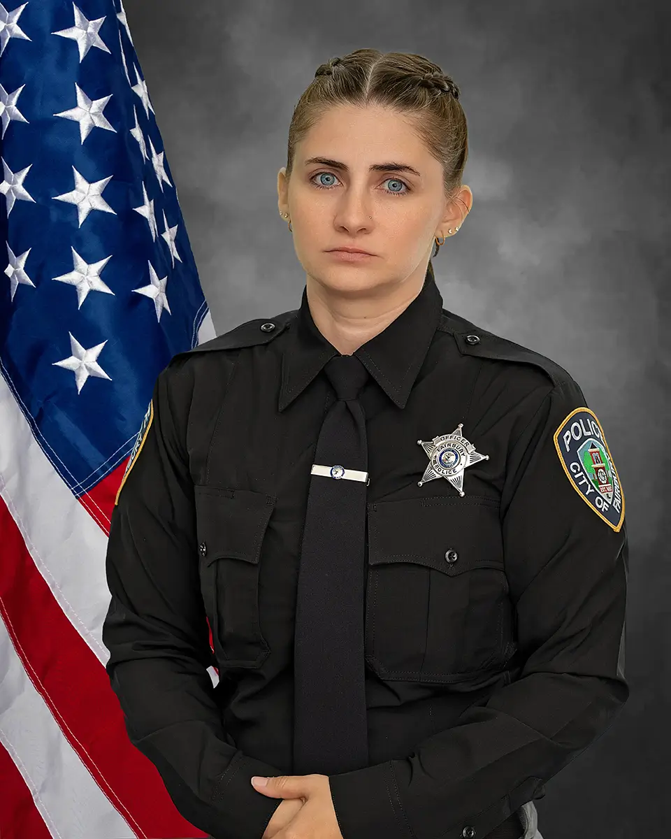 Formal portrait of City of Fairbury police officer in uniform with American flag
