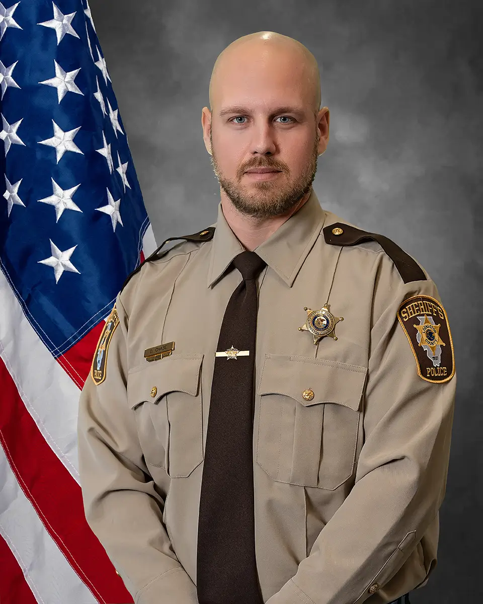 Formal portrait of Livingston County Sheriff's deputy in uniform with American flag